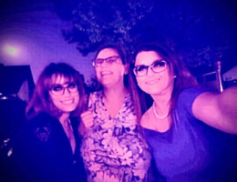 Purple tinted photo of three women in glasses smiling